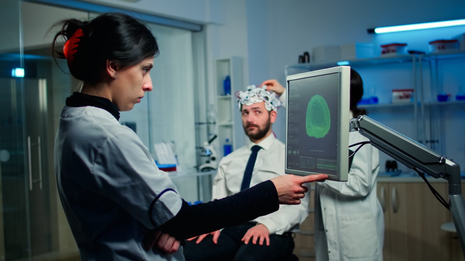 Woman researcher looking at monitor analysing brain scan while coworker discussing with patient in background about side effects, mind functions, nervous system, tomography scan working in laboratory SSUCv3H4sIAAAAAAAACnRTTY/TMBD9K5XPdbEd20l6Q2IRIHaFtAgOW7Qaf6QxTePIcRahqv+dcbocOHCxHM+b92beTC7EwBws2V9IGIZlzglyiCPZsy1JfnQ+rdeXVGm23rwLOaYAw/plINt+hLMn+3EZhuuWzBnyMvu5ME59zNEtI0YrDFnI/oi5t+Cr7tOlvJM9+eBhyL2F5N/co4hFBWRbDIbuw2z9MMDo4zKT6/ZvyqMNfrT+f7gfWwJHBPxGuSvqJz94WEt7IkYYEL6yVFZcUdk4S41hknaVcpxzcM50yKudVDVvGyosVFQywWjT1o5CVXPhjADuCkx10mguHbWqQzZlGgoNHh4cq7RtW6skwhzvtJWopxQXVDphKEjfUuZq2XFuOu0YwgRrQHPQlHOhqZS6pg2rJWWmctw2ikOrCTZ3+pV9OhczsTlYXIjF15eI1s03x6cUbBiPN0TMfZkmmheXMSd0haDYEOMEZsARdZjmt6SHeUaAe30oc8O1iOcbyRhzMbBkOhwn3ngldCNa3A8mm4pVqinzWLegD5hYhC5lQOeQs0faf/aCo21VYWjKhBBuT8G9thQQTGontWEKTZKGU9mJmrbCCKo0SNNxX1vrUHCZhgguFwcws4vpvG5Ighk9WttEVybIPT7e7Q8Hvtt8j+mE5my+lGrmw0HXzW7z/m7zGUzEvwAL39DN4xRTXuHv4ugPh4ePD5/efnt+ZFzjwfjzVyx+p9p293M6kusfAAAA//8DANIr+3xPAwAA