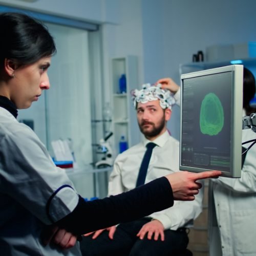 Woman researcher looking at monitor analysing brain scan while coworker discussing with patient in background about side effects, mind functions, nervous system, tomography scan working in laboratory SSUCv3H4sIAAAAAAAACnRTTY/TMBD9K5XPdbEd20l6Q2IRIHaFtAgOW7Qaf6QxTePIcRahqv+dcbocOHCxHM+b92beTC7EwBws2V9IGIZlzglyiCPZsy1JfnQ+rdeXVGm23rwLOaYAw/plINt+hLMn+3EZhuuWzBnyMvu5ME59zNEtI0YrDFnI/oi5t+Cr7tOlvJM9+eBhyL2F5N/co4hFBWRbDIbuw2z9MMDo4zKT6/ZvyqMNfrT+f7gfWwJHBPxGuSvqJz94WEt7IkYYEL6yVFZcUdk4S41hknaVcpxzcM50yKudVDVvGyosVFQywWjT1o5CVXPhjADuCkx10mguHbWqQzZlGgoNHh4cq7RtW6skwhzvtJWopxQXVDphKEjfUuZq2XFuOu0YwgRrQHPQlHOhqZS6pg2rJWWmctw2ikOrCTZ3+pV9OhczsTlYXIjF15eI1s03x6cUbBiPN0TMfZkmmheXMSd0haDYEOMEZsARdZjmt6SHeUaAe30oc8O1iOcbyRhzMbBkOhwn3ngldCNa3A8mm4pVqinzWLegD5hYhC5lQOeQs0faf/aCo21VYWjKhBBuT8G9thQQTGontWEKTZKGU9mJmrbCCKo0SNNxX1vrUHCZhgguFwcws4vpvG5Ighk9WttEVybIPT7e7Q8Hvtt8j+mE5my+lGrmw0HXzW7z/m7zGUzEvwAL39DN4xRTXuHv4ugPh4ePD5/efnt+ZFzjwfjzVyx+p9p293M6kusfAAAA//8DANIr+3xPAwAA